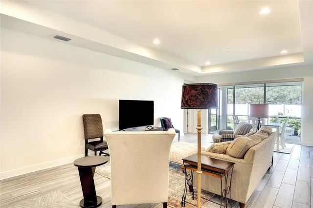 a living room with furniture a flat screen tv and a floor to ceiling window