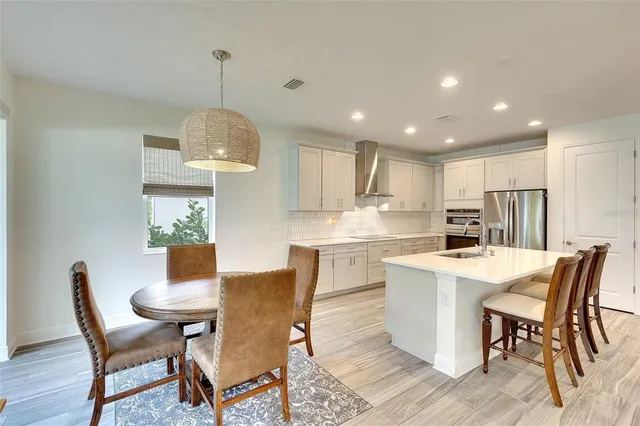 a view of a dining room with furniture a chandelier and wooden floor