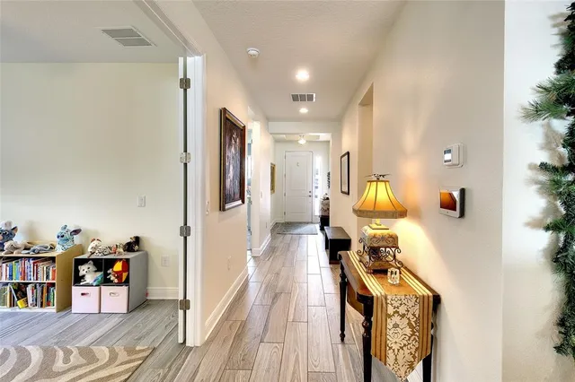 a living room with a bed furniture flat screen tv and windows