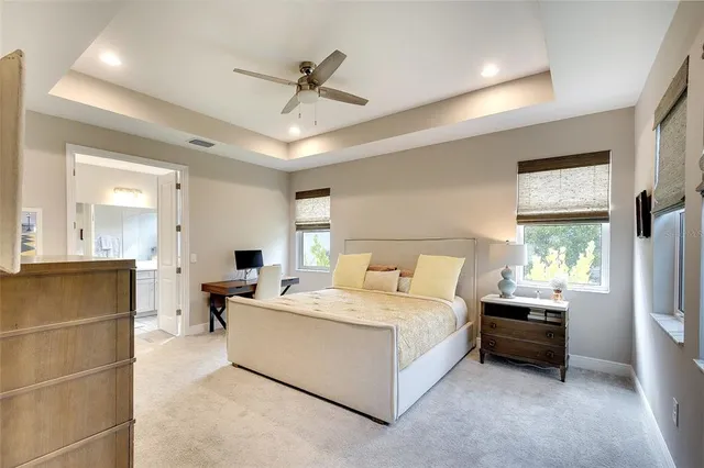 a spacious bedroom with a bed a chandelier and a window
