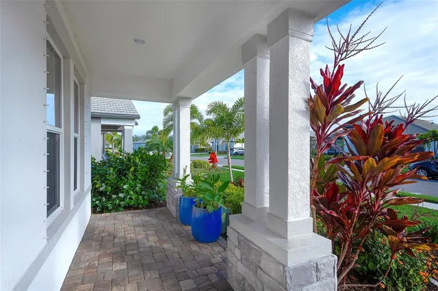 a vase with flowers sitting on a floor in front of a door