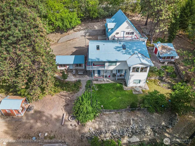 a aerial view of a house with a yard and large trees