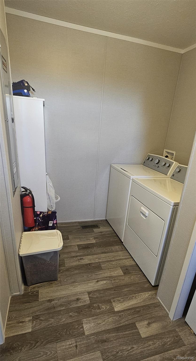 29 Hickory Ridge Davison, MI 48423 - Photo 17 of 26 Laundry room with dark wood-type flooring, ornamental molding, and washer and dryer