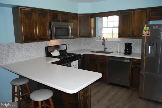 a kitchen with a sink a stove a microwave and cabinets