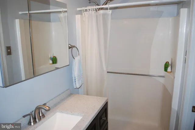 a bedroom with a bed a painting and a book shelf