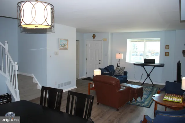 a living room with furniture a window and wooden floor