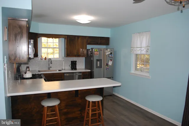 a kitchen with stainless steel appliances a sink cabinets and wooden floor