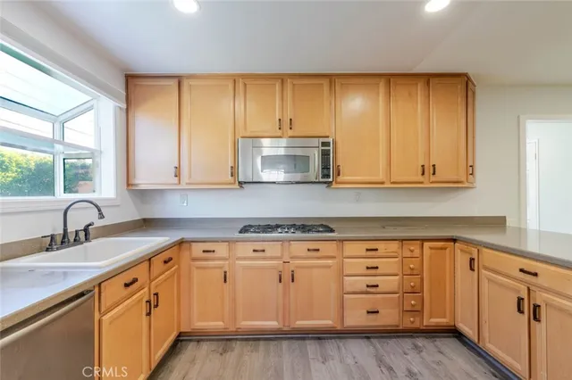 a view of a kitchen with wooden floor and electronic appliances