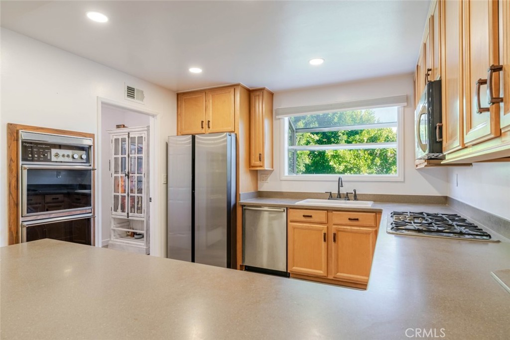 18301 Minnehaha Street Porter Ranch, CA 91326 - Photo 24 of 32 a kitchen with stainless steel appliances granite countertop a refrigerator and a sink
