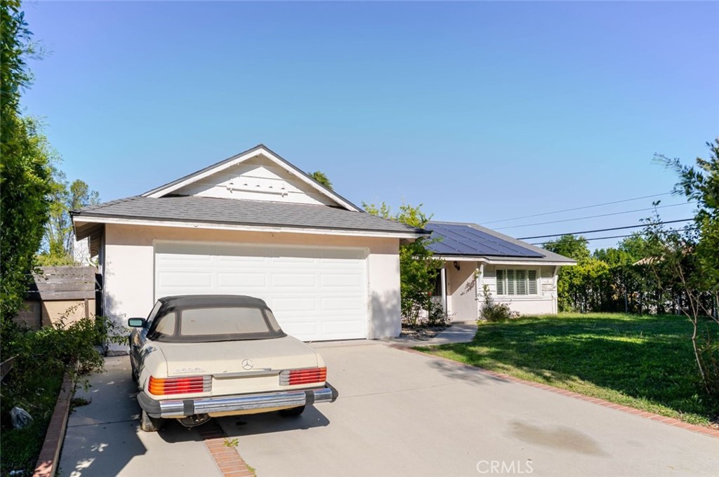 18301 Minnehaha Street Porter Ranch, CA 91326 - Photo 32 of 32 a car parked in front of house with a yard