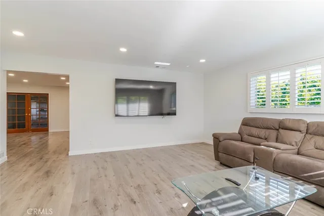 a view of an empty room with a kitchen and a window