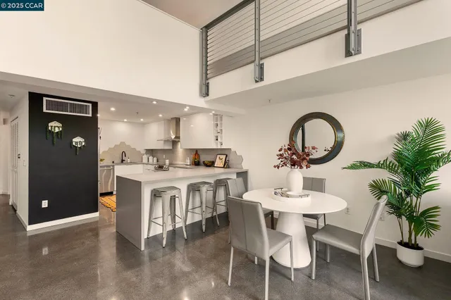 a kitchen with a dining table chairs and white cabinets
