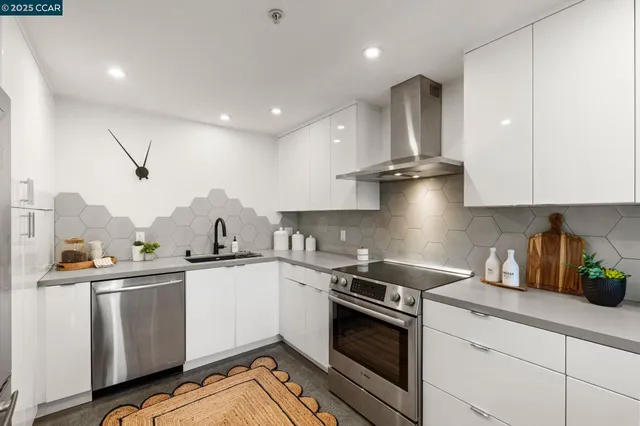 a kitchen with stainless steel appliances granite countertop a sink a stove and a refrigerator