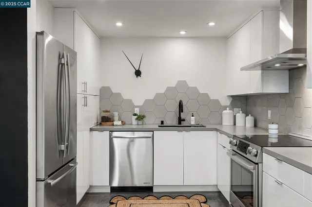 a kitchen with stainless steel appliances granite countertop a sink a stove and a refrigerator