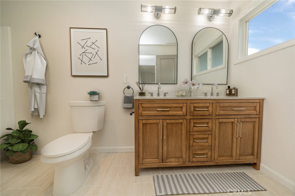 18863 8th Street Bloomington, CA 92316 - Photo 11 of 23 a bathroom with a granite countertop toilet sink and mirror
