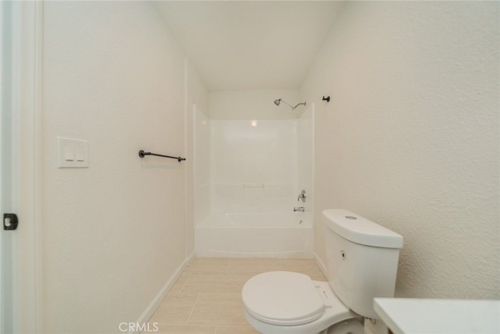 18863 8th Street Bloomington, CA 92316 - Photo 12 of 23 a white toilet sitting next to a bathroom sink