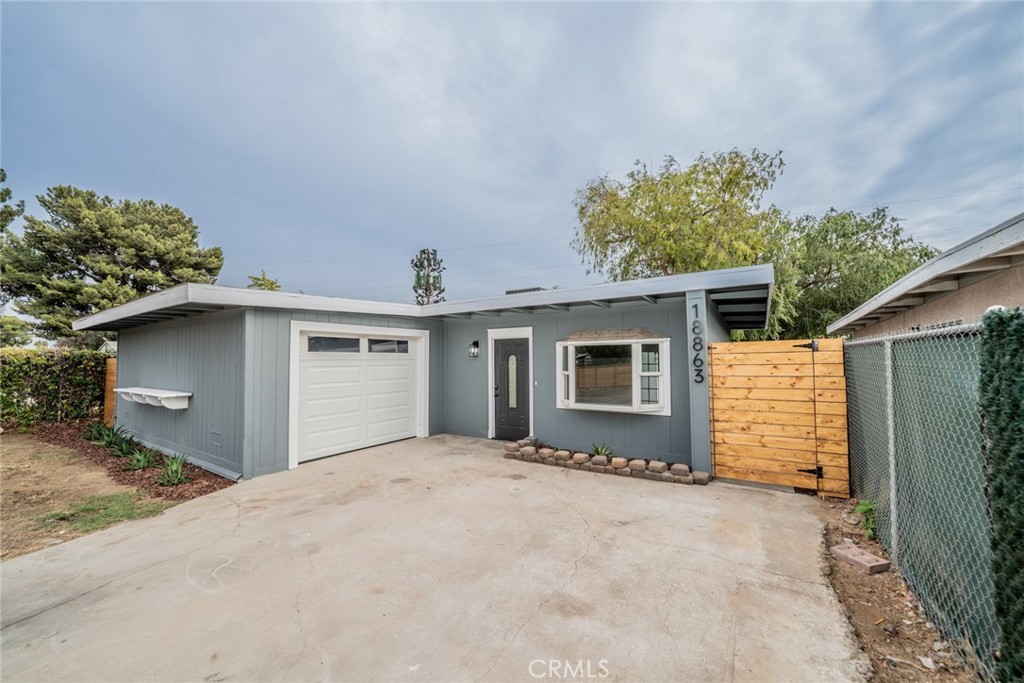 18863 8th Street Bloomington, CA 92316 - Photo 2 of 23 a view of a house with a yard and garage