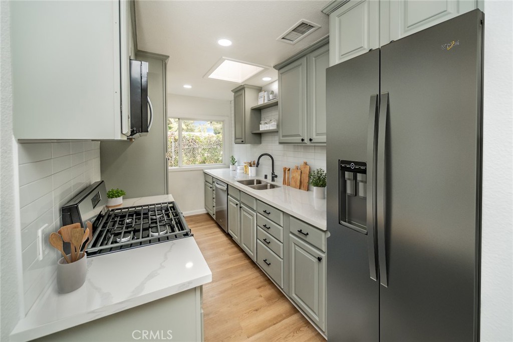 18863 8th Street Bloomington, CA 92316 - Photo 5 of 23 a kitchen with sink a refrigerator and stove