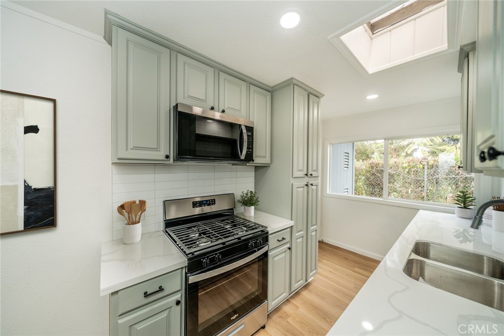 18863 8th Street Bloomington, CA 92316 - Photo 6 of 23 a kitchen with stainless steel appliances a stove a sink and a microwave
