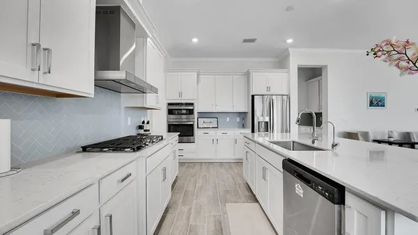 a kitchen with stainless steel appliances a sink stove refrigerator and cabinets