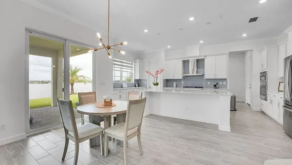 a kitchen with a dining table chairs and white cabinets