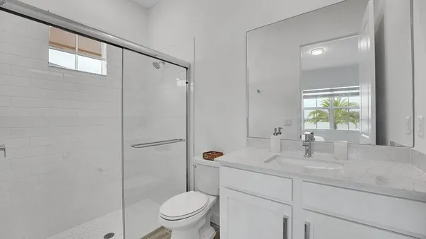 a bathroom with a granite countertop sink toilet and shower