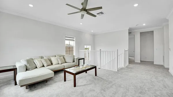 a living room with furniture and a ceiling fan