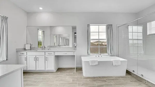 a bathroom with a double vanity sink mirror and bathtub