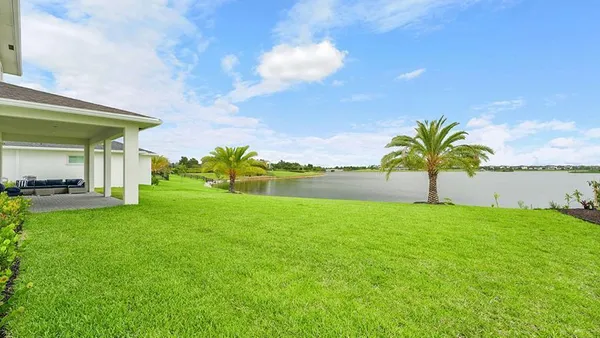 a view of a house with a big yard and large trees