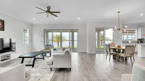 a view of a a dining room with furniture window and wooden floor