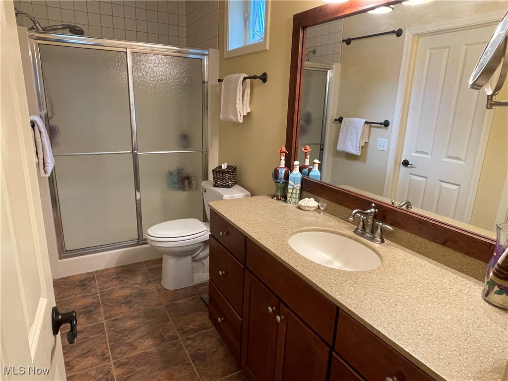 8322 Forest Ridge Street Northwest Massillon, OH 44646 - Photo 26 of 33 Full bathroom featuring vanity, a stall shower, and dark tile patterned flooring