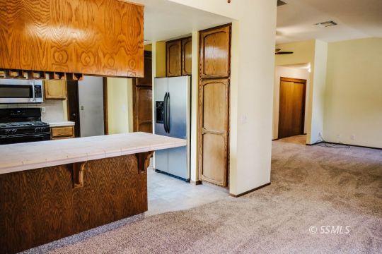 420 Veada Avenue Ridgecrest, CA 93555 - Photo 10 of 41 a kitchen with stainless steel appliances a refrigerator and a stove