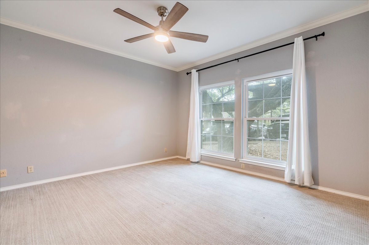 3809 Spicewood Springs Road, Unit 127 Austin, TX 78759 - Photo 12 of 29 Well-lit room featuring twin windows with leafy views, enhanced by a classic ceiling fan.