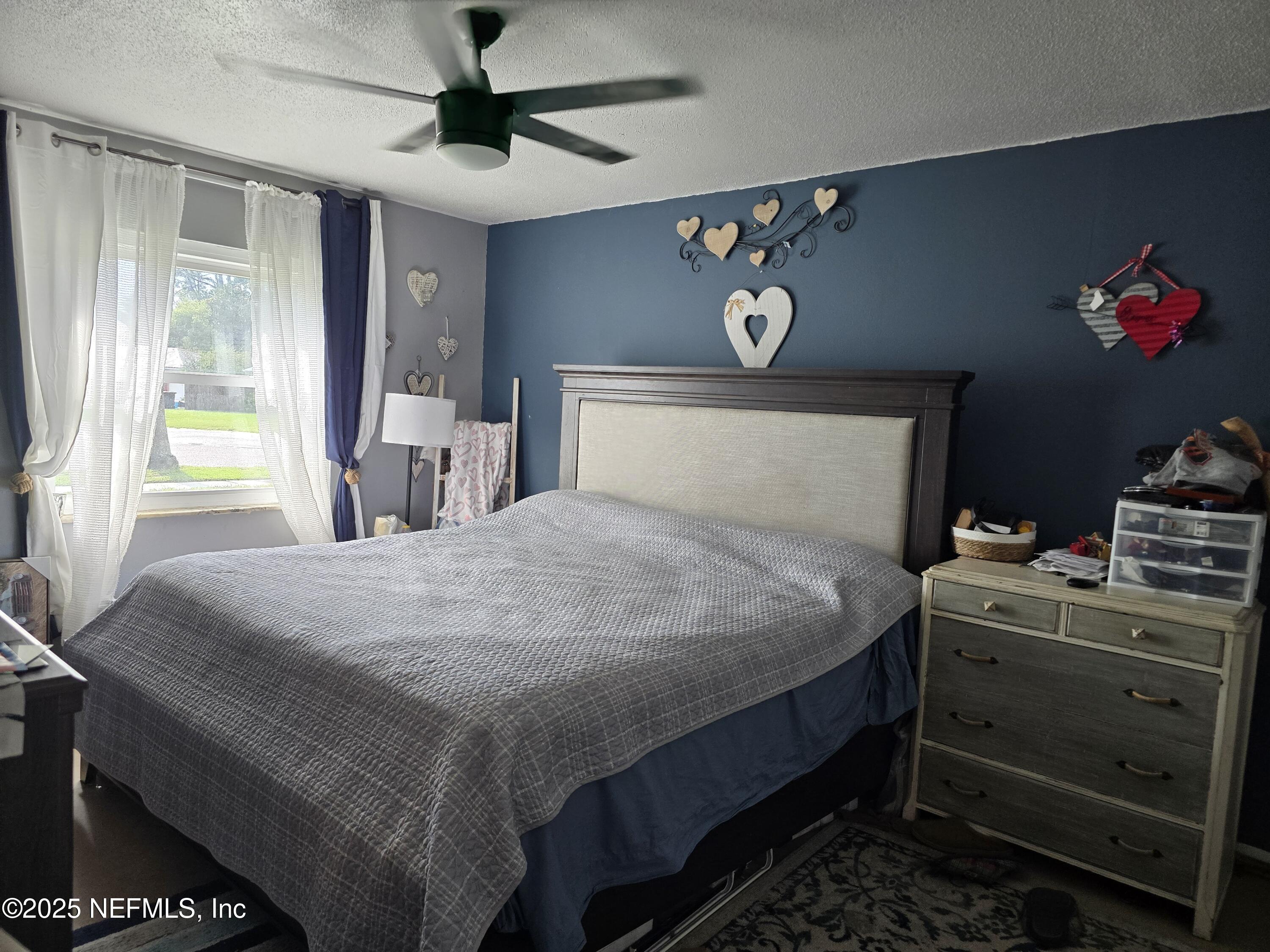 6051 Foxfire Court Jacksonville, FL 32244 - Photo 12 of 31 a bedroom with a bed and a chandelier