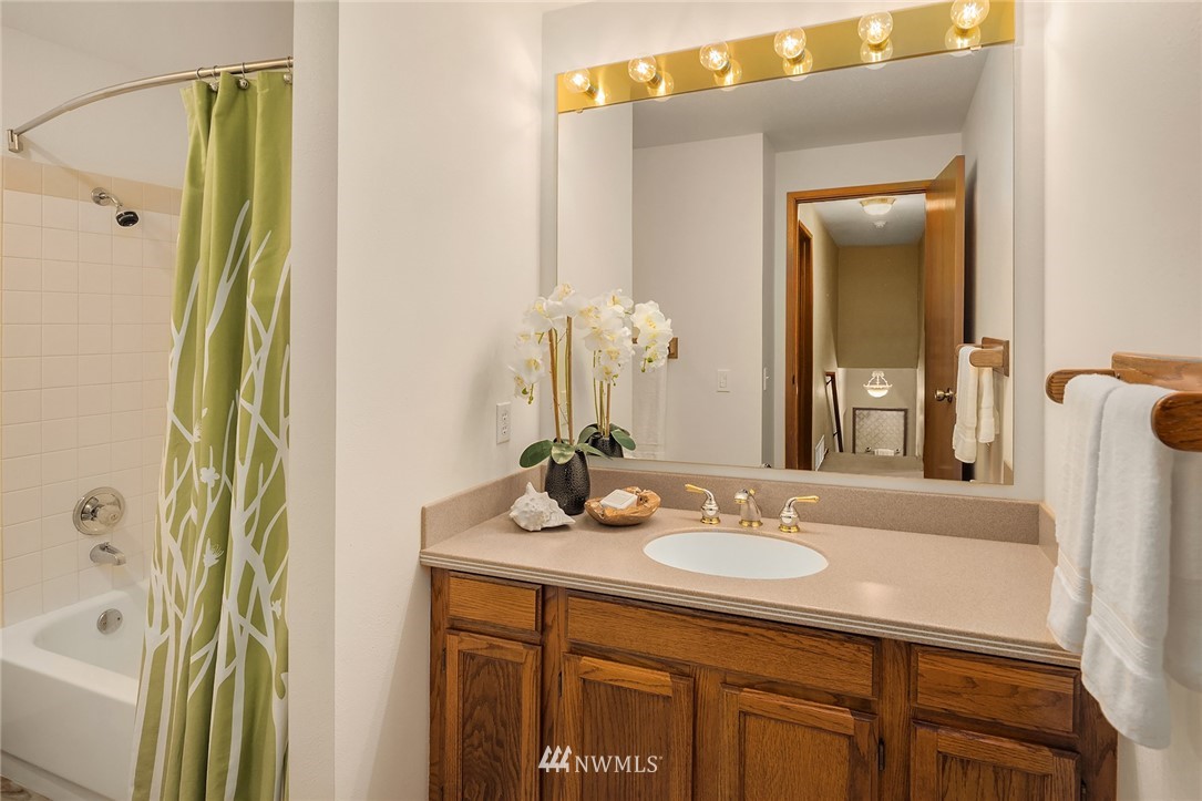 1133 South 23rd Street Renton, WA 98055 - Photo 26 of 38 a bathroom with a granite countertop sink a mirror a vanity and shower
