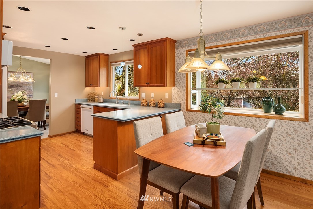 1133 South 23rd Street Renton, WA 98055 - Photo 10 of 38 a kitchen with stainless steel appliances granite countertop a table chairs and a wooden floor