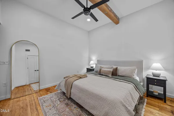 a bedroom with a bed and a lamp on the dresser