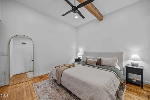 a bedroom with a bed and a lamp on the dresser