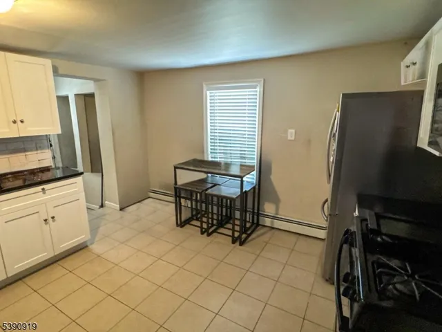 a living room with a table chairs and a refrigerator