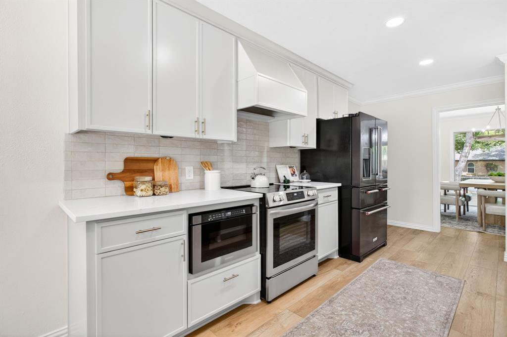 4316 Winding Way Benbrook, TX 76126 - Photo 12 of 40 a kitchen with stainless steel appliances granite countertop a stove a refrigerator and a microwave
