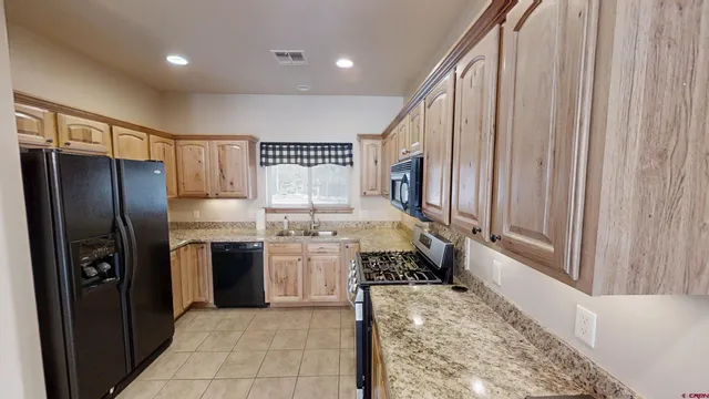 a kitchen with stainless steel appliances granite countertop a refrigerator and a sink