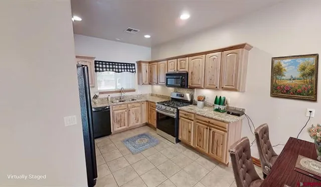 a kitchen with stainless steel appliances granite countertop a stove top oven a sink dishwasher and a refrigerator