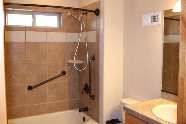 a bathroom with a shower a toilet and a sink