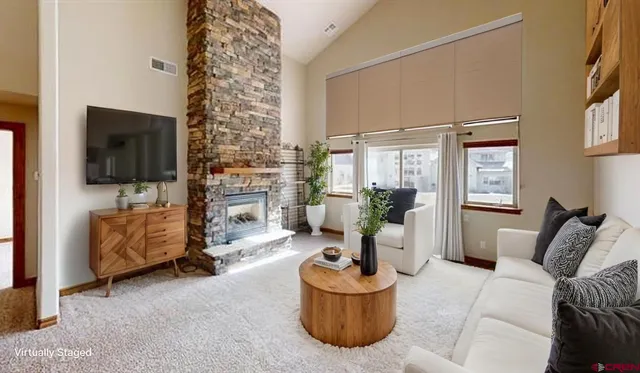 a living room with furniture a flat screen tv and a fireplace