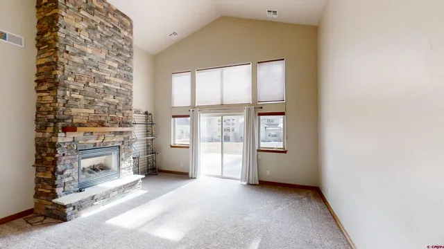 a view of an empty room with a fireplace and a window