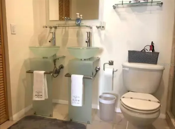 a white toilet sitting next to a bathroom sink and vanity