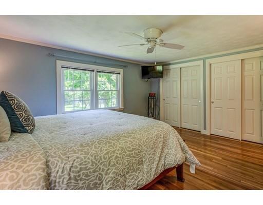 25 Woodside Road Topsfield, MA 01983 - Photo 24 of 37 a bedroom with a bed and a chandelier
