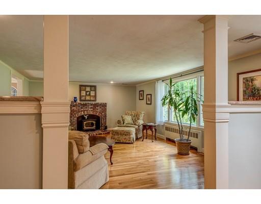 25 Woodside Road Topsfield, MA 01983 - Photo 5 of 37 a living room with furniture a fireplace and a floor to ceiling window