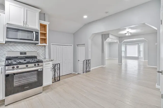 a kitchen with stainless steel appliances granite countertop a stove and a microwave