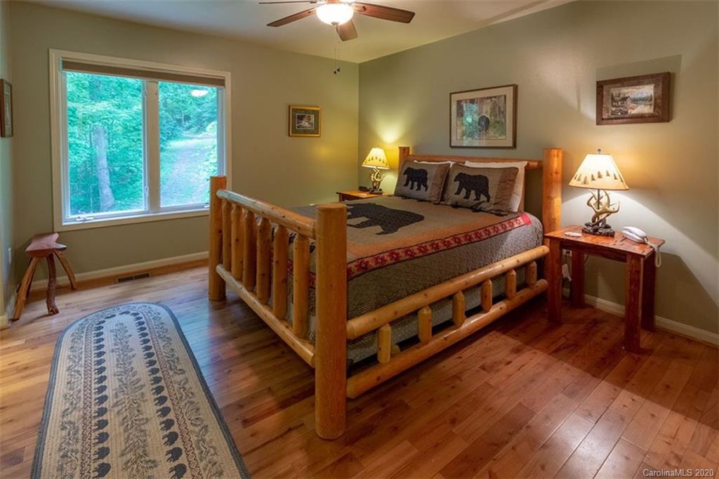 136 Dars Lane Tuckasegee, NC 28783 - Photo 17 of 48 a bedroom with a bed and a chandelier
